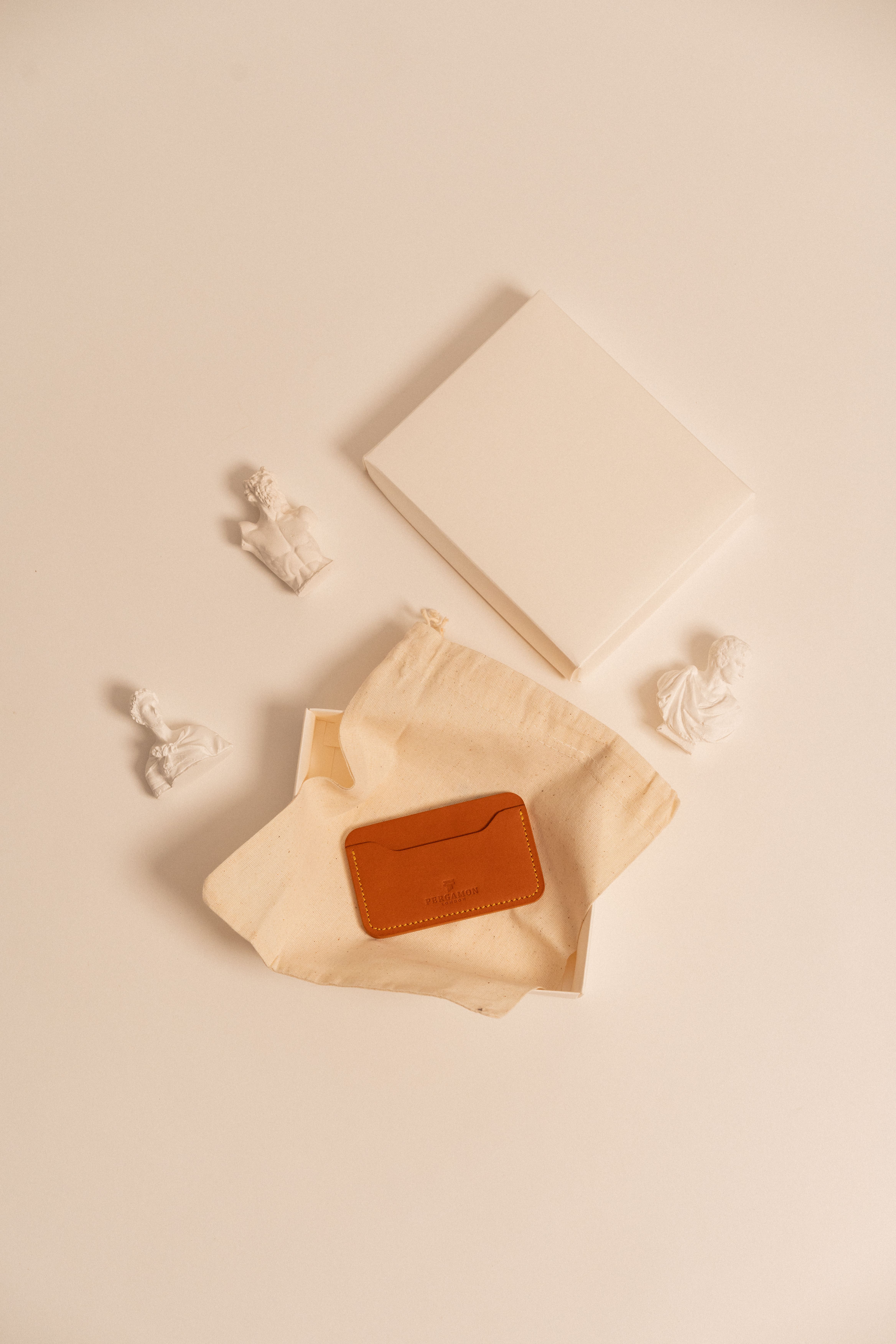 Porte-cartes en cuir tan présenté dans une pochette en lin